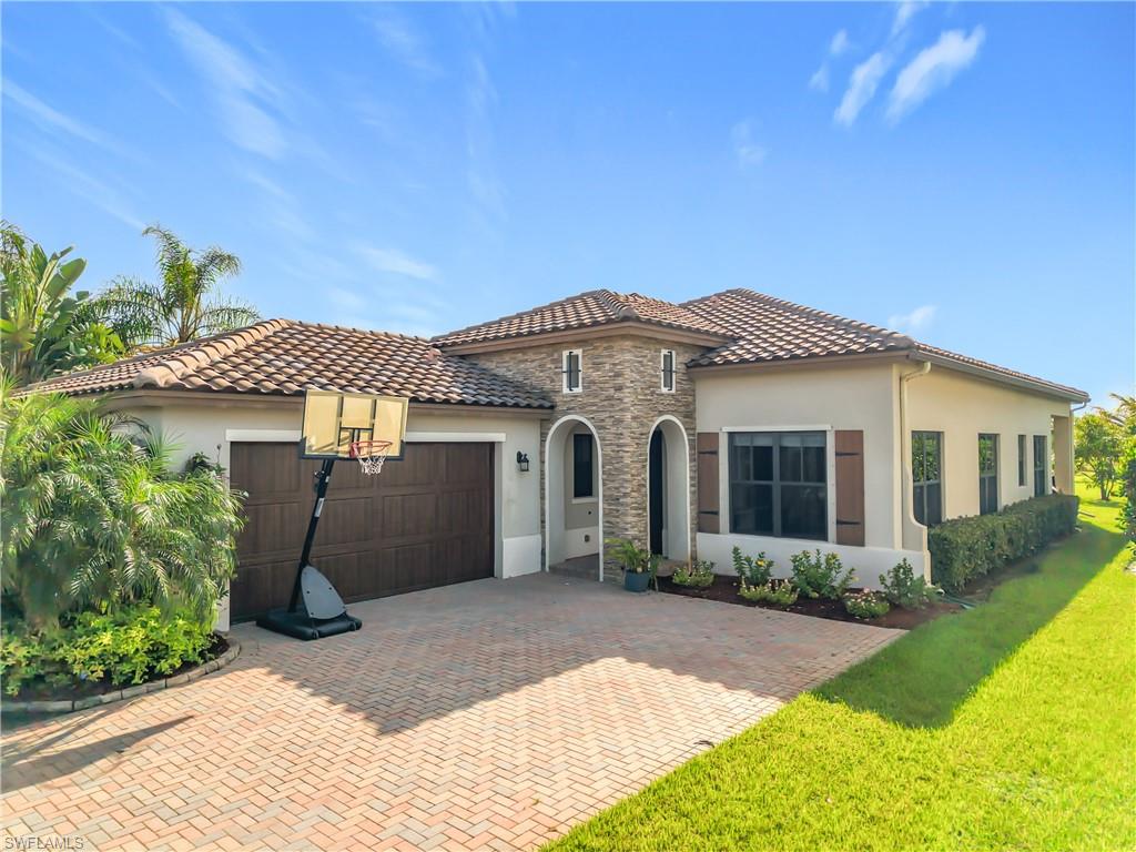 5118 Genoa Street Ave Maria, FL 34142 - Photo 1 of 28 a front view of a house with a yard and garage