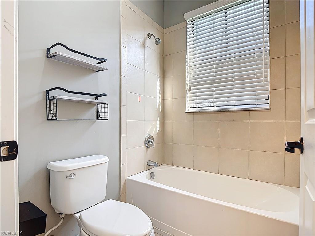 5118 Genoa Street Ave Maria, FL 34142 - Photo 25 of 28 a white toilet sitting next to a bath tub and a shower