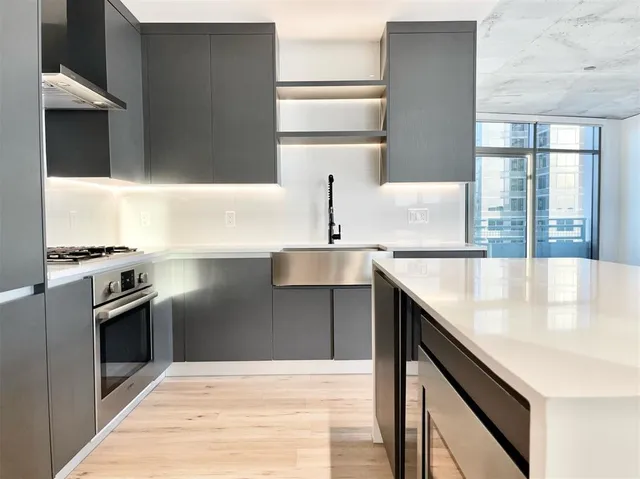 a kitchen with stainless steel appliances granite countertop a sink and a refrigerator