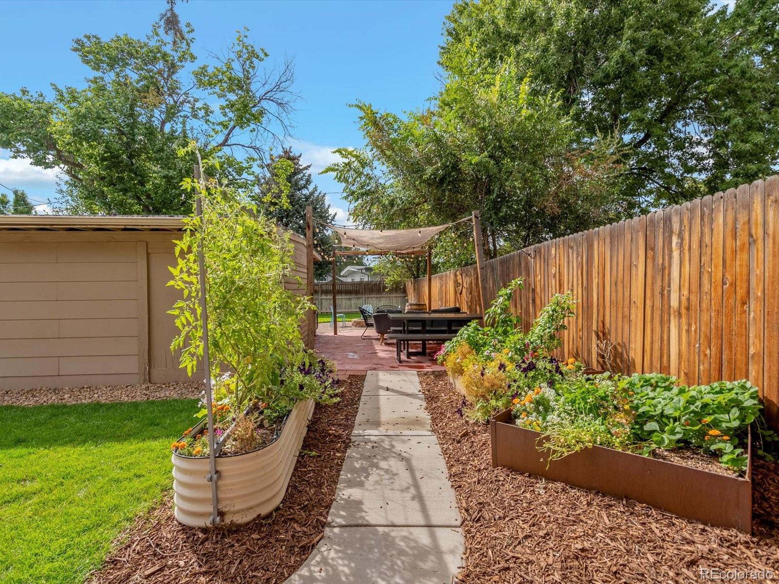 4963 North Harlan Street Wheat Ridge, CO 80033 - Photo 33 of 42 a view of a backyard with potted plants and a fountain