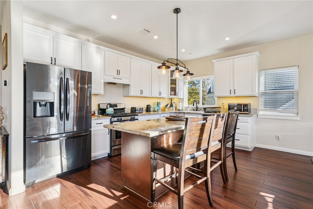 26845 Modoc Lane Lake Arrowhead, CA 92352 - Photo 15 of 56 a kitchen with stainless steel appliances granite countertop a refrigerator a stove a sink dishwasher a refrigerator white cabinets and wooden floor