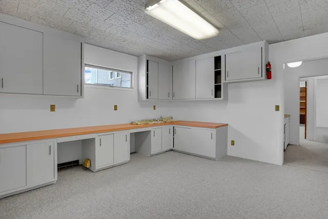a living room with stainless steel appliances kitchen island granite countertop a stove and a refrigerator
