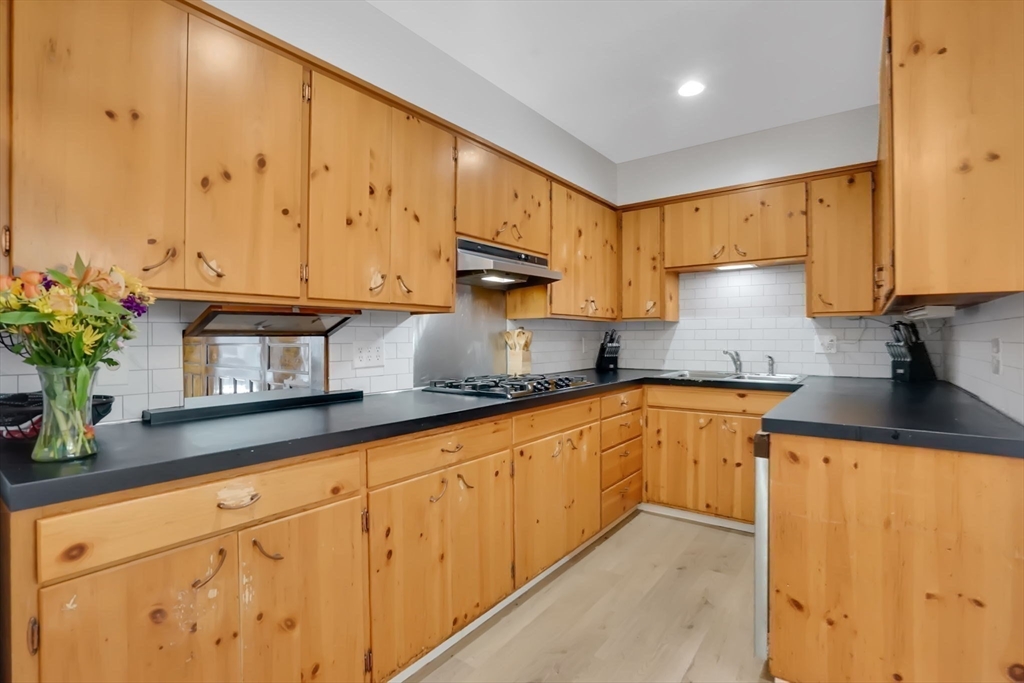 264 Sumner Avenue Springfield, MA 01108 - Photo 9 of 32 a kitchen with granite countertop white cabinets sink and stainless steel appliances