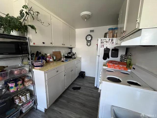 a kitchen with a white stove top oven and cabinets