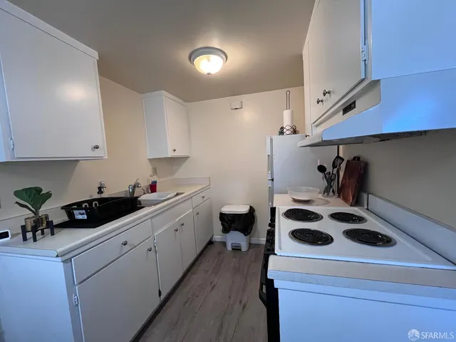 a kitchen with a sink a stove and cabinets