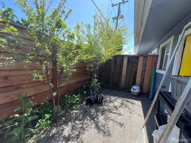 a view of backyard with potted plants and wooden fence