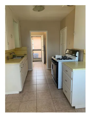 a kitchen with a stove top oven and cabinets