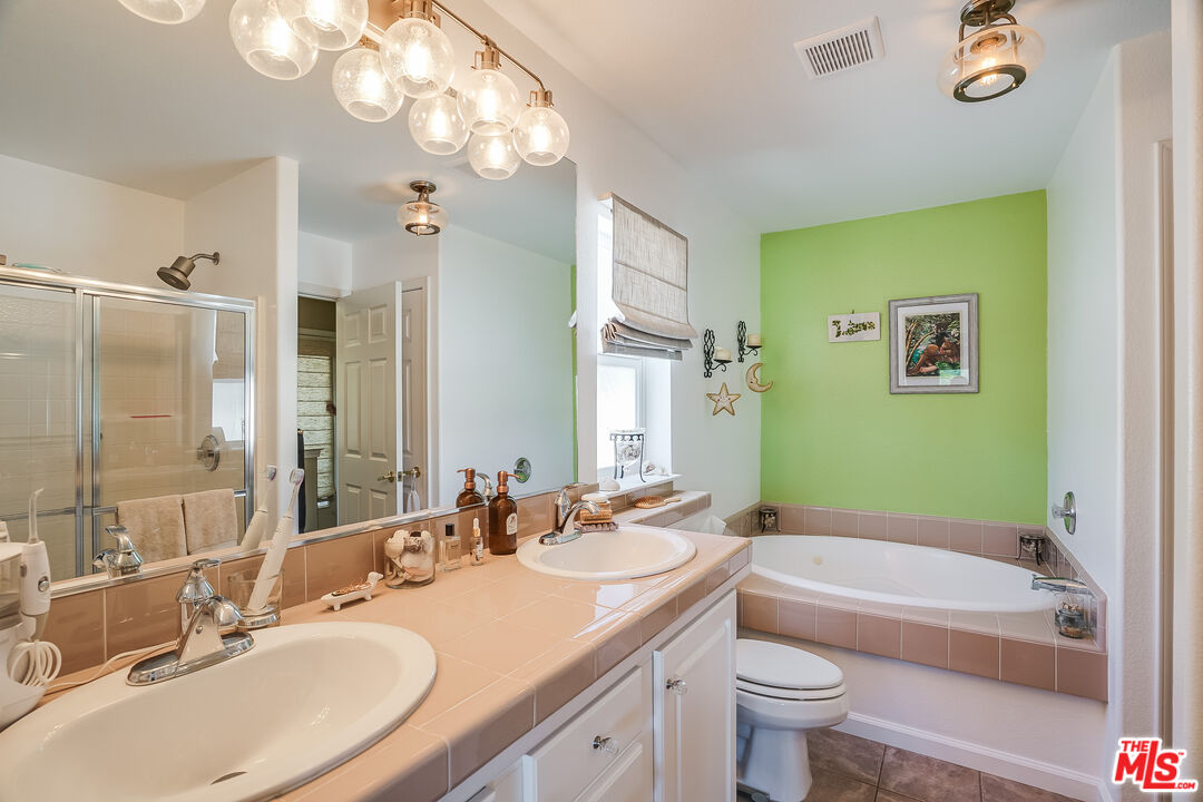 182 Comanche Topanga, CA 90290 - Photo 16 of 24 a bathroom with a granite countertop sink a toilet a mirror a bathtub and shower