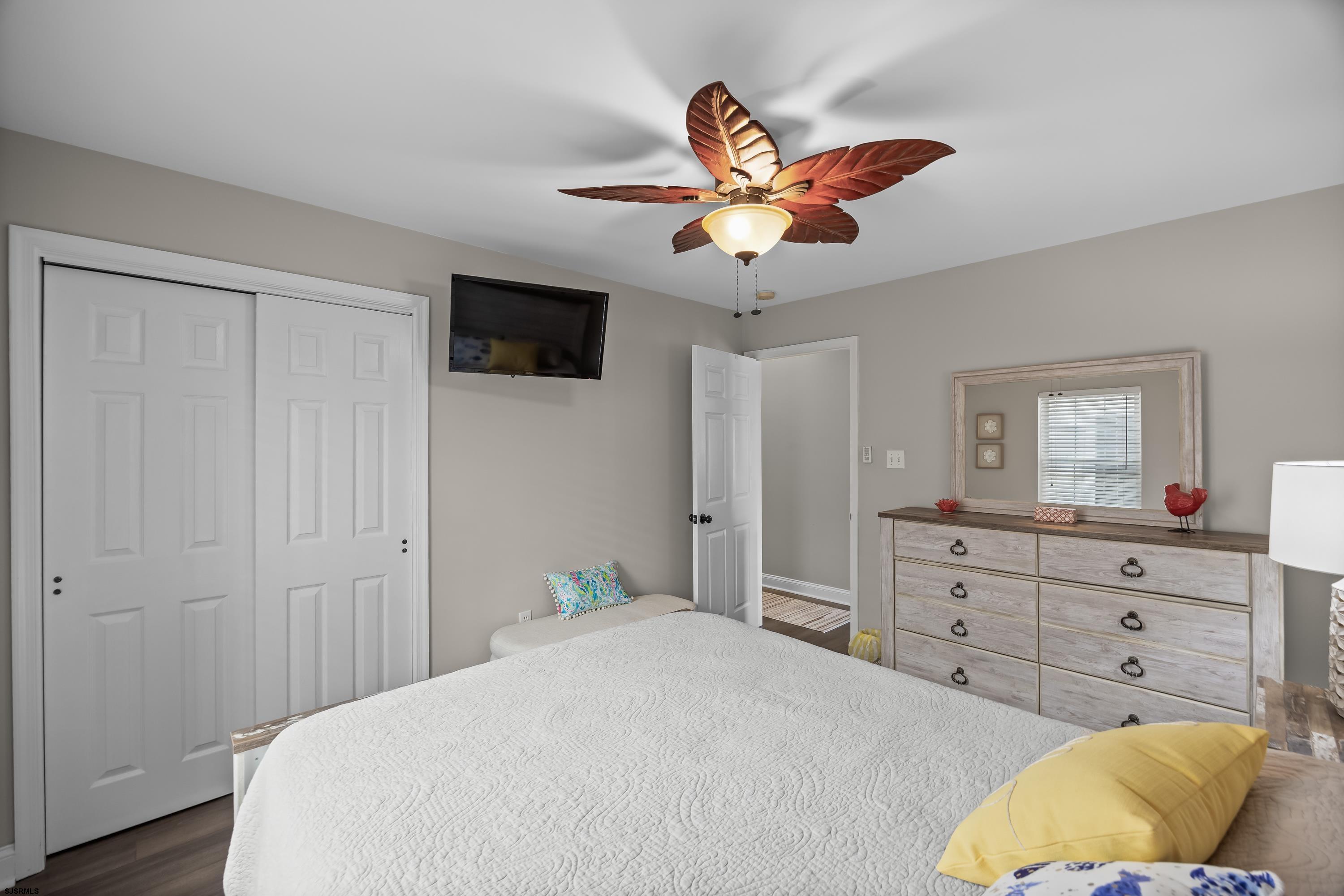 405 Atlantic Avenue, Unit 1 Ocean City, NJ 08226 - Photo 26 of 39 a bedroom with a bed and a chandelier