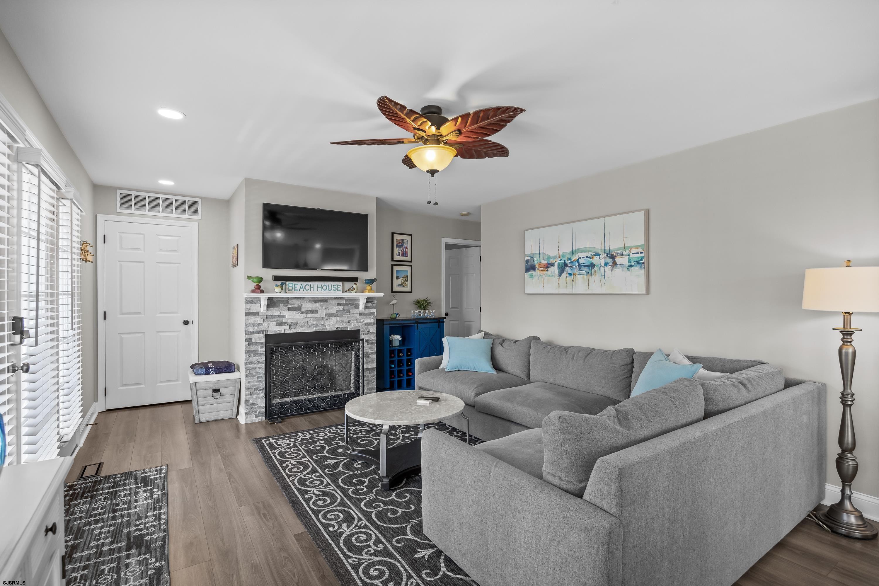405 Atlantic Avenue, Unit 1 Ocean City, NJ 08226 - Photo 9 of 39 a living room with furniture a flat screen tv and a fireplace