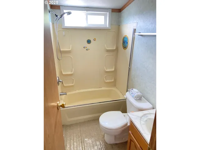 a bathroom with a granite countertop toilet and a shower