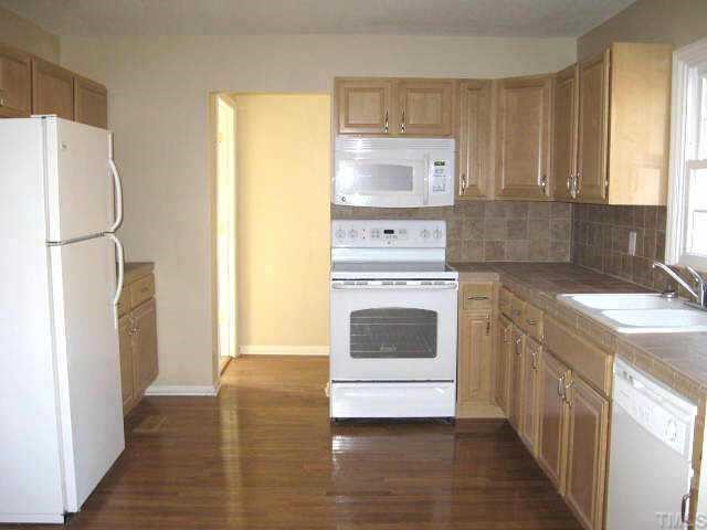 122 Stedwick Place Durham, NC 27712 - Photo 5 of 12 a kitchen with a refrigerator sink stove and cabinets