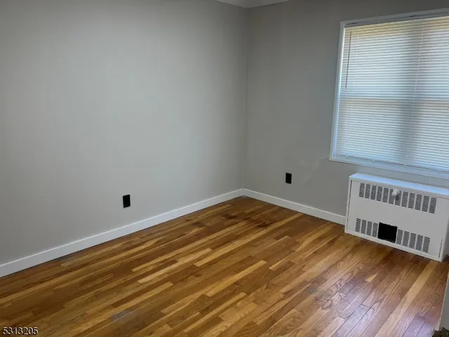 a view of a room with wooden floor and a window