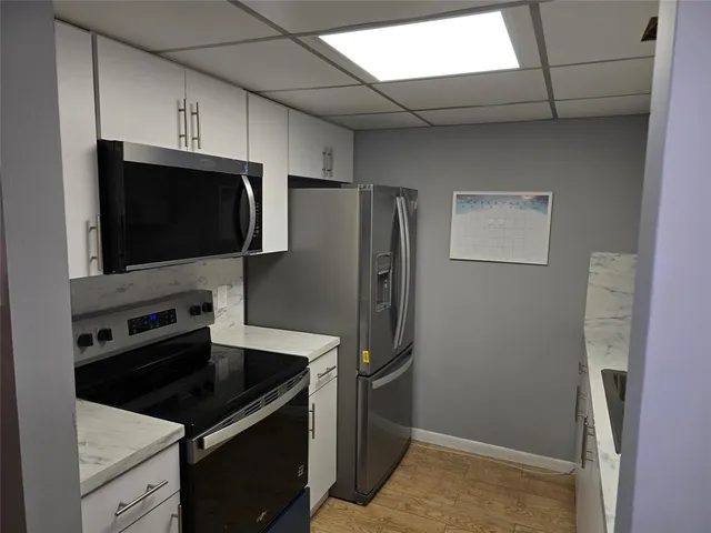 a kitchen with stainless steel appliances granite countertop a refrigerator and a sink