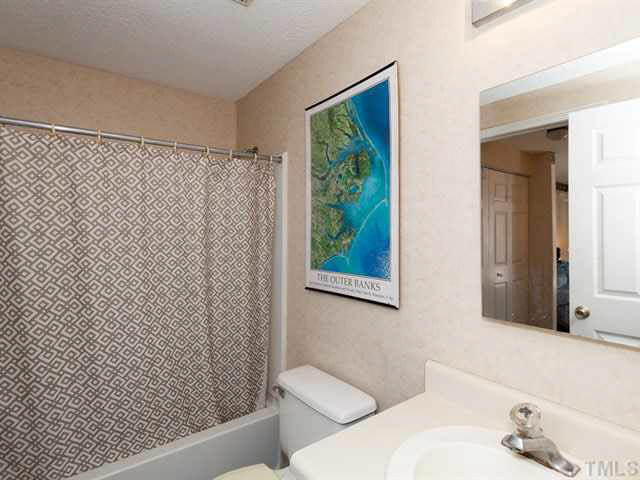 7722 Bernadette Lane Raleigh, NC 27615 - Photo 12 of 23 a bathroom with a shower curtain and a sink