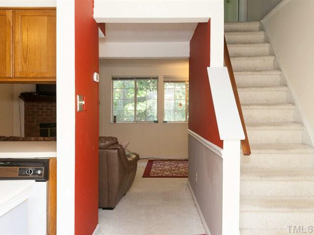 7722 Bernadette Lane Raleigh, NC 27615 - Photo 2 of 23 a view of a hallway with wooden cabinets and staircase