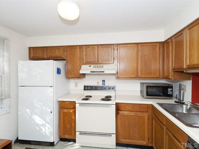 7722 Bernadette Lane Raleigh, NC 27615 - Photo 3 of 23 a kitchen with a white cabinets and white appliances