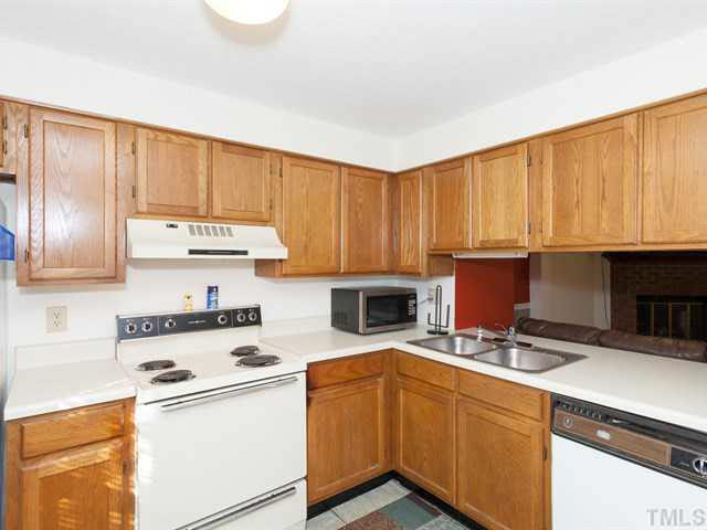 7722 Bernadette Lane Raleigh, NC 27615 - Photo 4 of 23 a kitchen with a stove a sink and a microwave