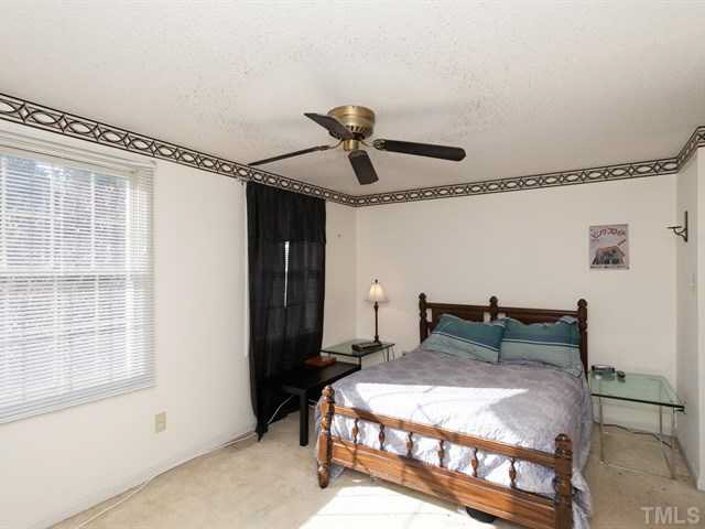 7722 Bernadette Lane Raleigh, NC 27615 - Photo 8 of 23 a bedroom with a bed and a chandelier