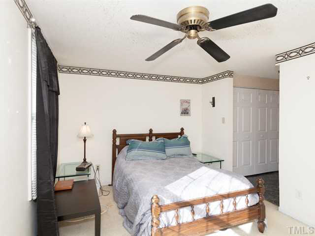 7722 Bernadette Lane Raleigh, NC 27615 - Photo 9 of 23 a bedroom with a bed and a chandelier