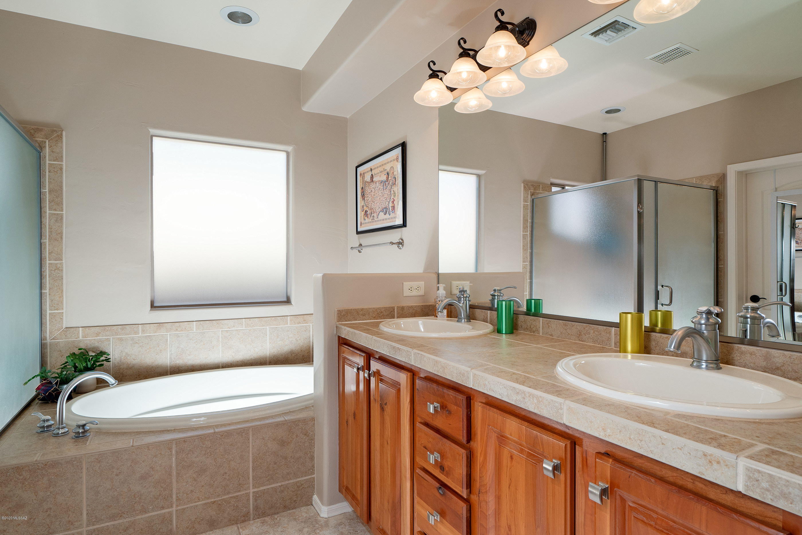 4440 West Crystal Ranch Place Marana, AZ 85658 - Photo 17 of 28 a bathroom with a granite countertop tub a sink and a mirror
