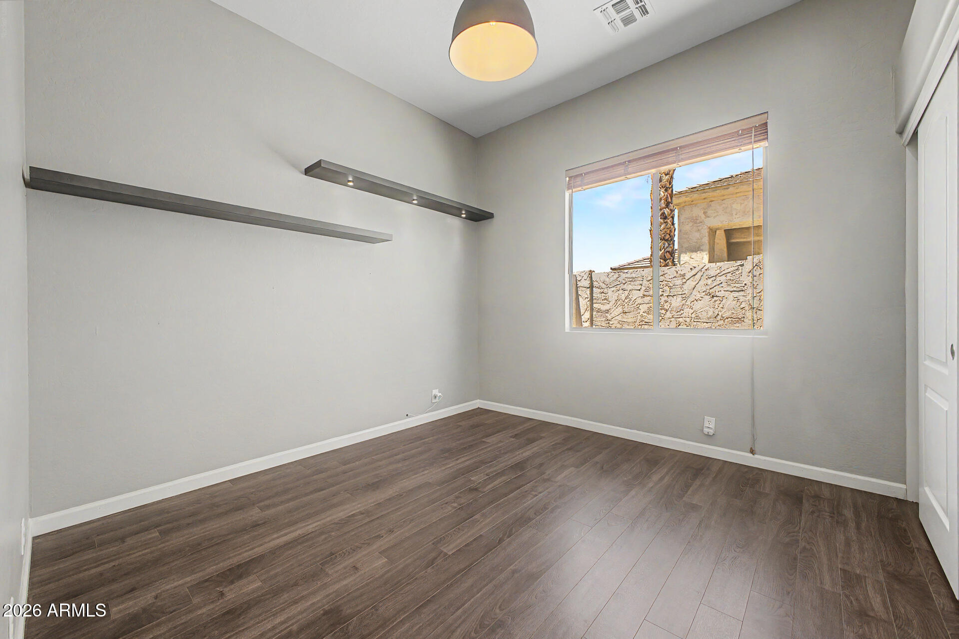 1632 West Frye Road Phoenix, AZ 85045 - Photo 18 of 37 an empty room with wooden floor and windows