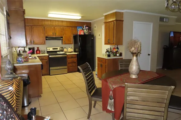 a kitchen with stainless steel appliances kitchen island granite countertop a refrigerator and a stove top oven