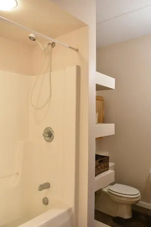 a white toilet sitting next to a shower