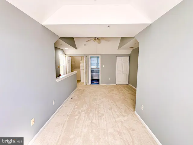 a view of empty room with wooden floor and cabinets
