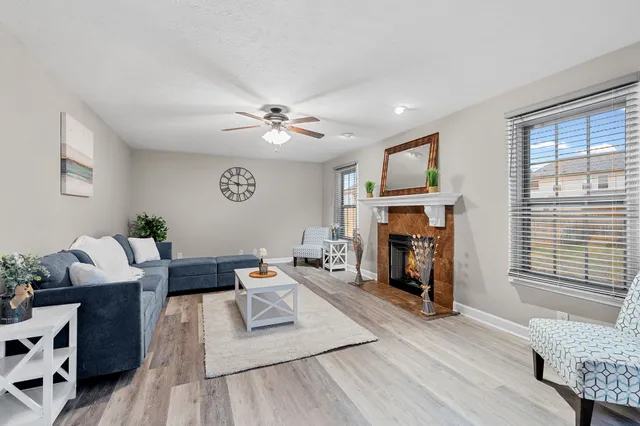 a living room with furniture a fireplace and a flat screen tv