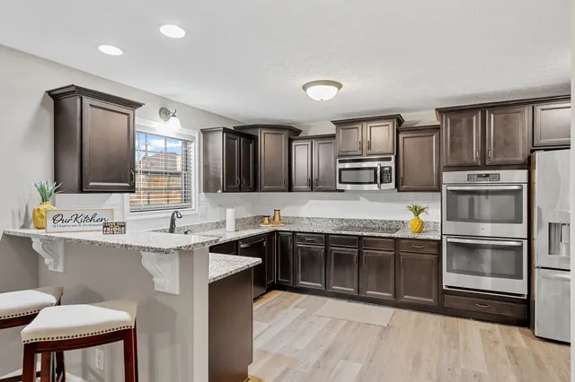 a kitchen with stainless steel appliances granite countertop a sink stove and refrigerator