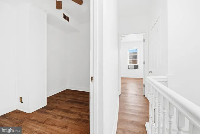 a view of a hallway with wooden floor and closet