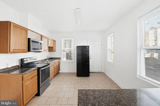 a kitchen with stainless steel appliances granite countertop a refrigerator stove top oven and sink