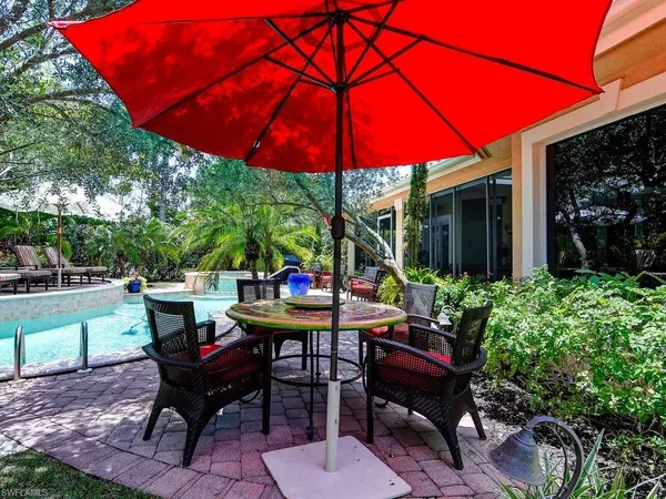 a view of a backyard with table and chairs under an umbrella
