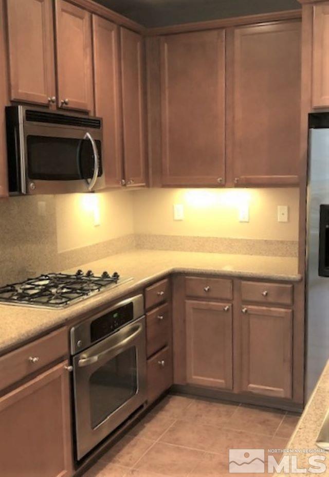 1845 Wind Ranch Road, Unit C Reno, NV 89521 - Photo 3 of 17 a kitchen with granite countertop a stove and a microwave
