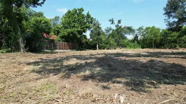 a backyard of a house with trees and wooden fence