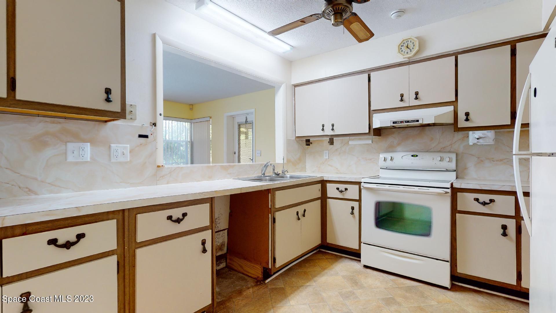 813 Vance Circle Northeast Palm Bay, FL 32905 - Photo 8 of 29 a kitchen with stainless steel appliances granite countertop white cabinets stove a sink and dishwasher