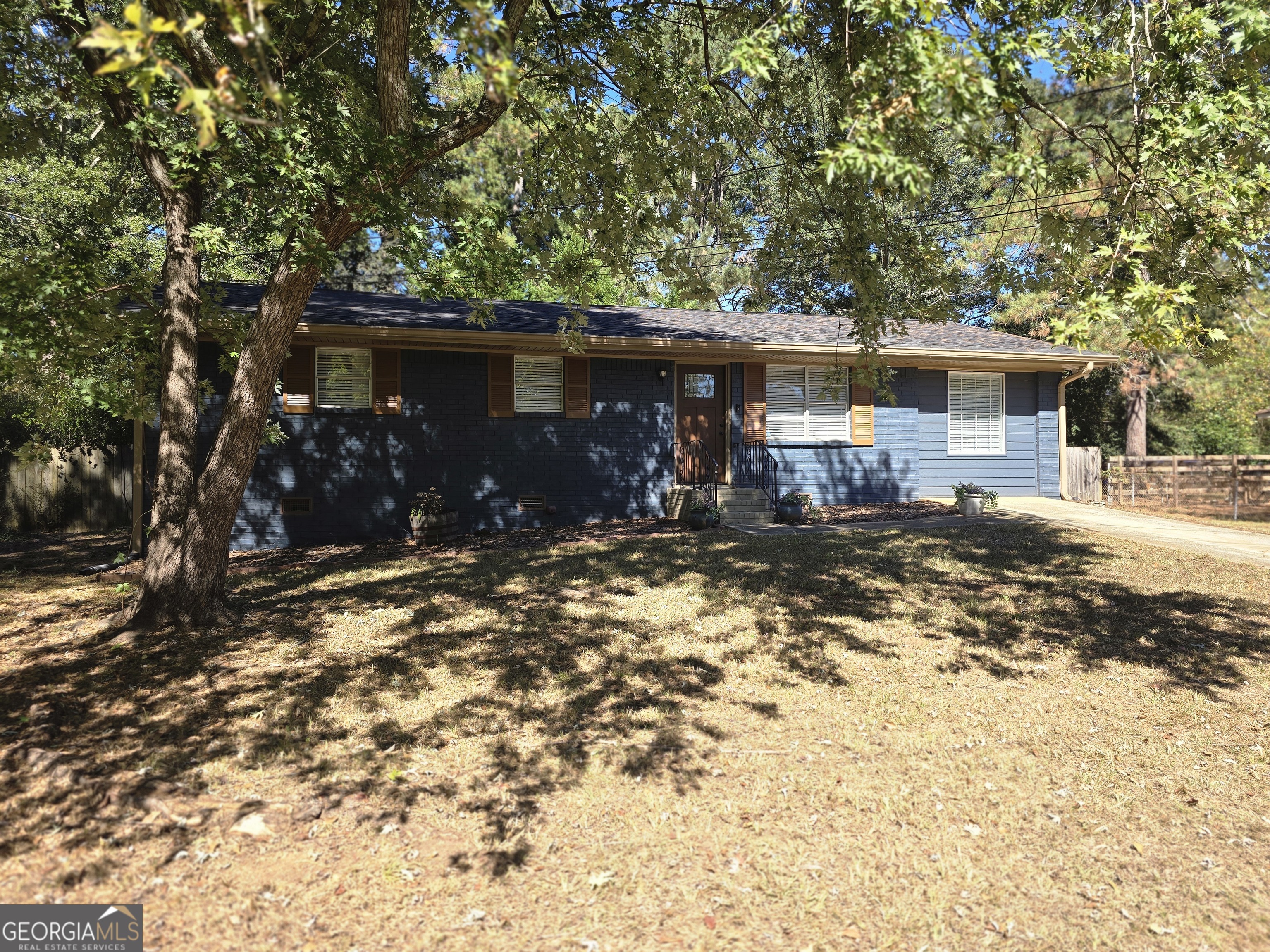 205 Emory Way Oxford, GA 30054 - Photo 1 of 18 a backyard of a house with table and chairs under an umbrella