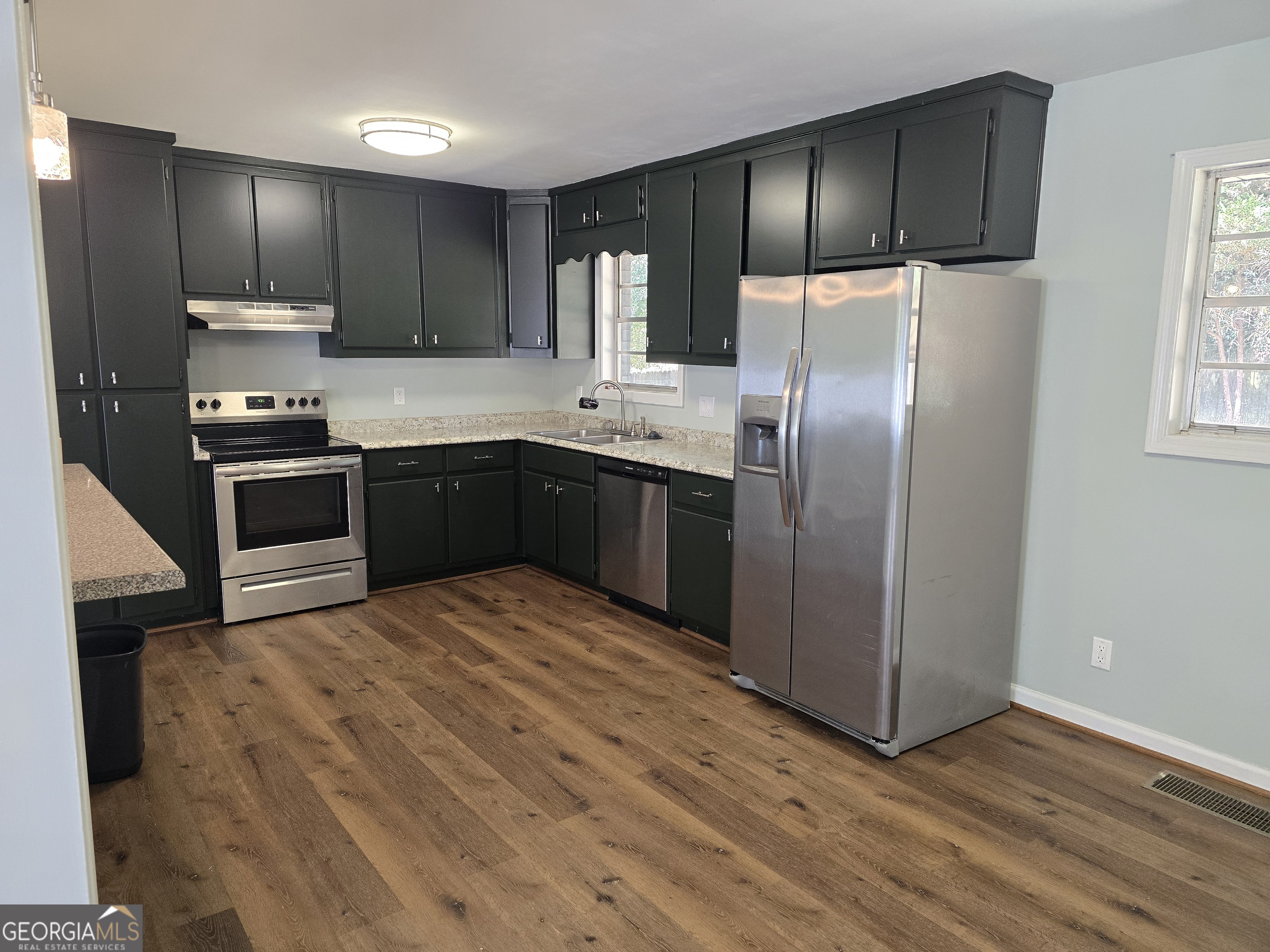 205 Emory Way Oxford, GA 30054 - Photo 8 of 18 a kitchen with stainless steel appliances granite countertop a refrigerator a stove a sink and dishwasher with wooden floor