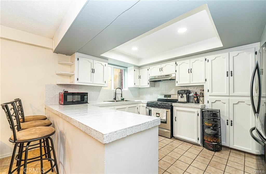 10334 Big Tujunga Canyon Road Tujunga, CA 91042 - Photo 2 of 5 a kitchen with a stove a refrigerator and white cabinets
