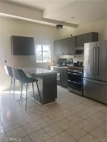 a kitchen with stainless steel appliances granite countertop a stove top oven microwave and a refrigerator