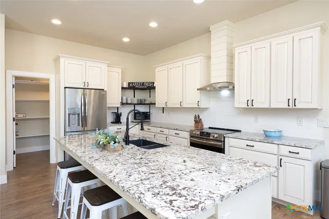 a kitchen with stainless steel appliances kitchen island granite countertop a refrigerator and stove