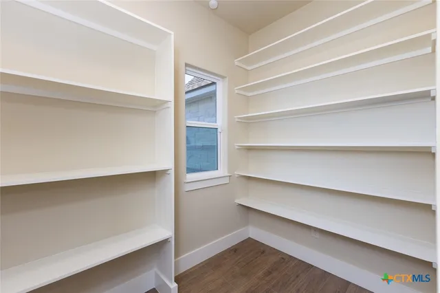 a view of walk in closet with empty racks
