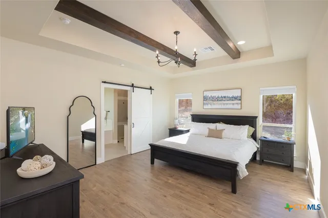 a bedroom with a bed and a table with wooden floor