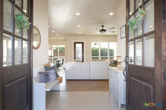 a large white kitchen with granite countertop a large window and a rug