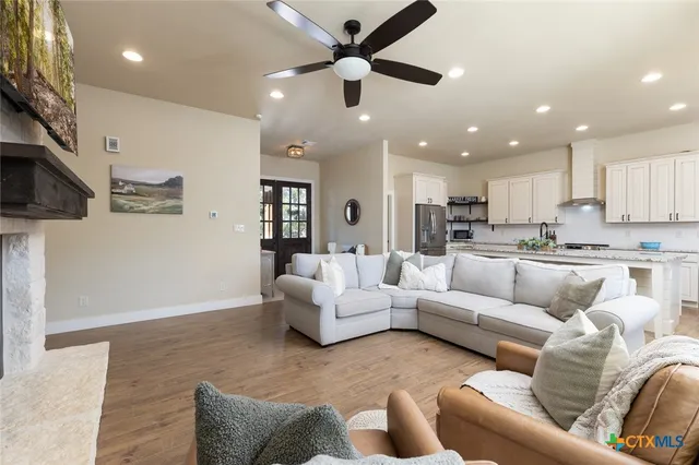 a living room with furniture kitchen view and a chandelier