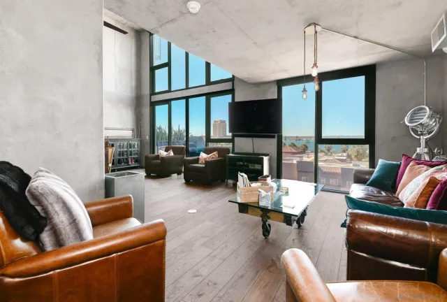 a living room with furniture fireplace and a large window