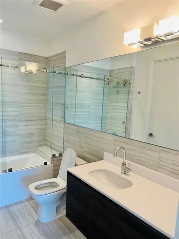 an empty room and a bathroom with a window