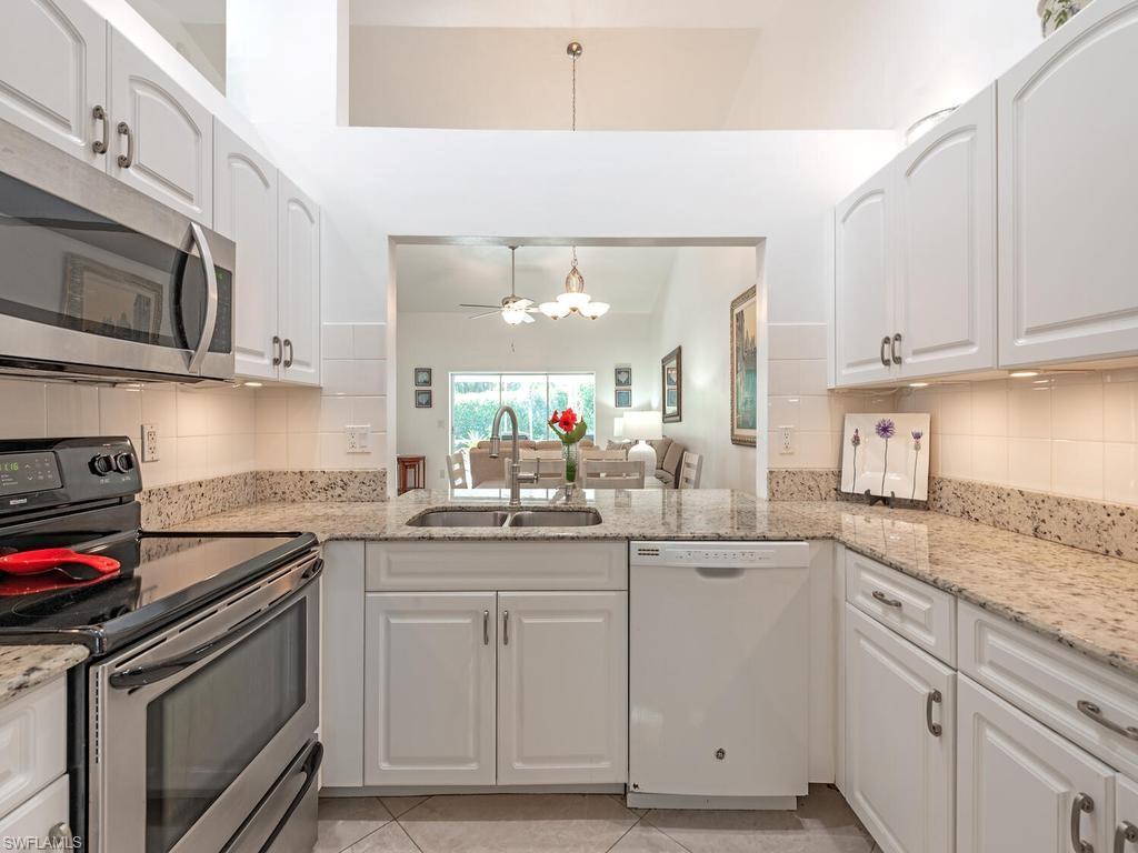 472 St Andrews Boulevard Naples, FL 34113 - Photo 11 of 18 a kitchen with granite countertop cabinets stainless steel appliances and a sink