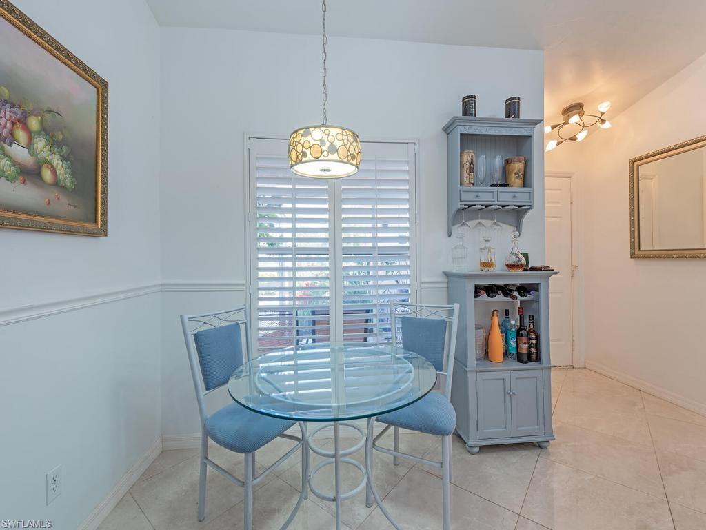 472 St Andrews Boulevard Naples, FL 34113 - Photo 12 of 18 a view of a dining room with furniture and wooden floor